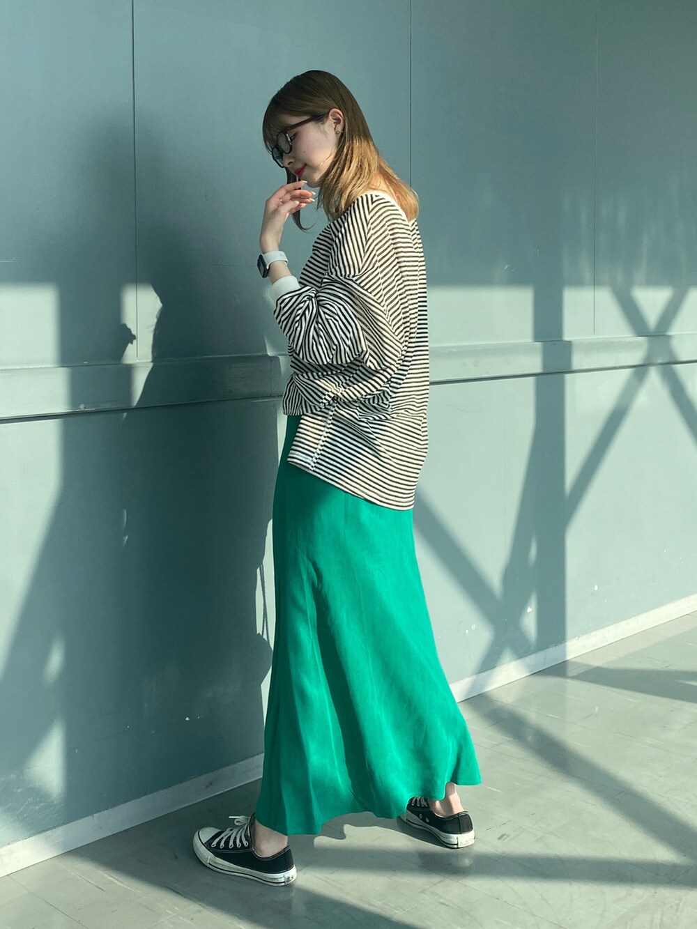 ブラック系のTシャツ/カットソー、グリーン系のスカート、ホワイト系のショルダーバッグを着用したレディースの春コーディネートの2枚目の写真
