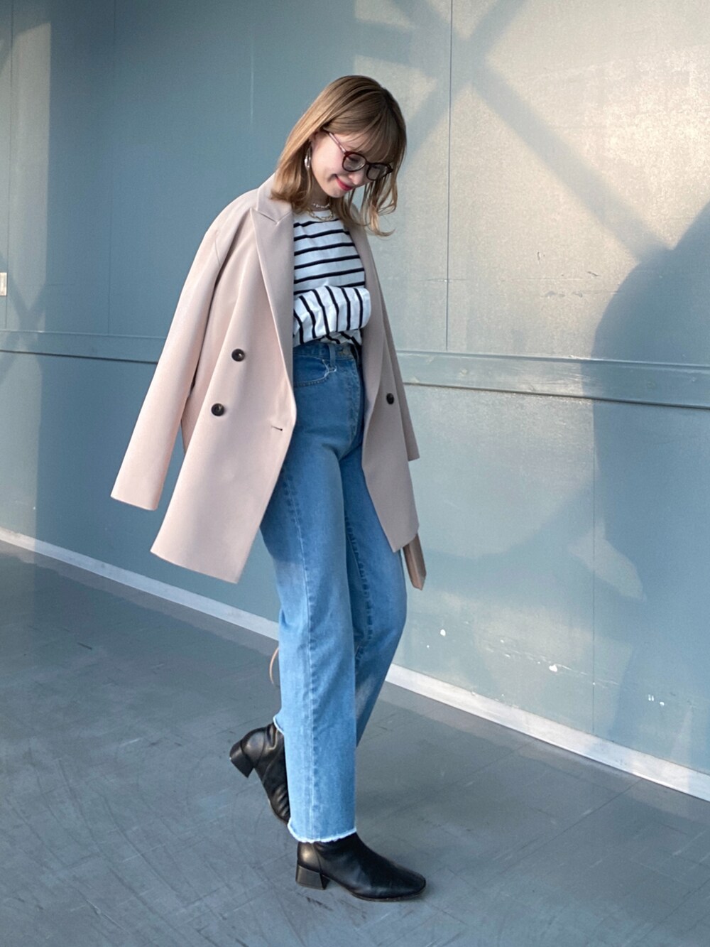 その他のTシャツ/カットソー、ブルー系のデニムパンツ、ベージュ系のショルダーバッグを着用したレディースの冬コーディネートの5枚目の写真