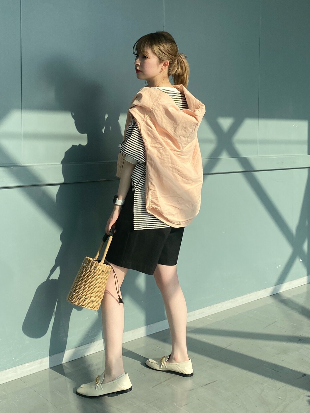 ブラック系のTシャツ/カットソー、ブラック系のその他パンツ、ベージュ系のかごバッグを着用したレディースの春コーディネートの2枚目の写真