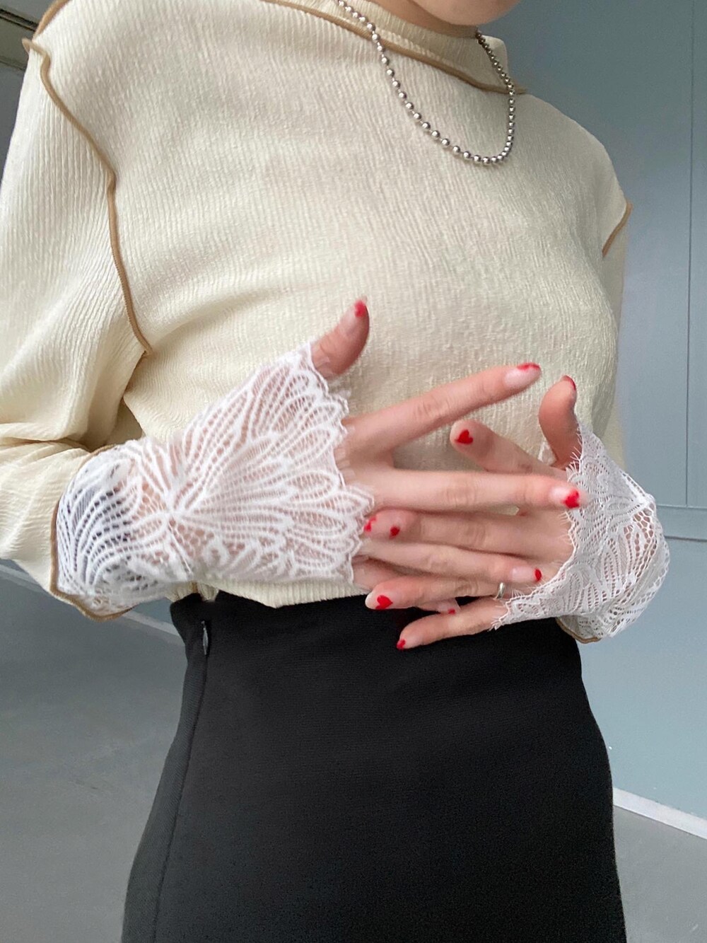 ホワイト系のTシャツ/カットソー、ブラック系のスカート、ホワイト系のショルダーバッグを着用したレディースの冬コーディネートの5枚目の写真