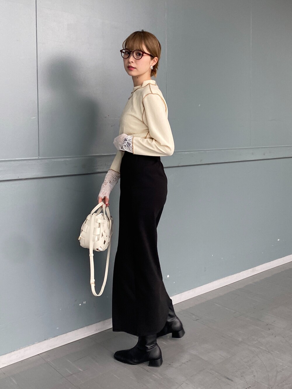 ホワイト系のTシャツ/カットソー、ブラック系のスカート、ホワイト系のショルダーバッグを着用したレディースの冬コーディネートの2枚目の写真