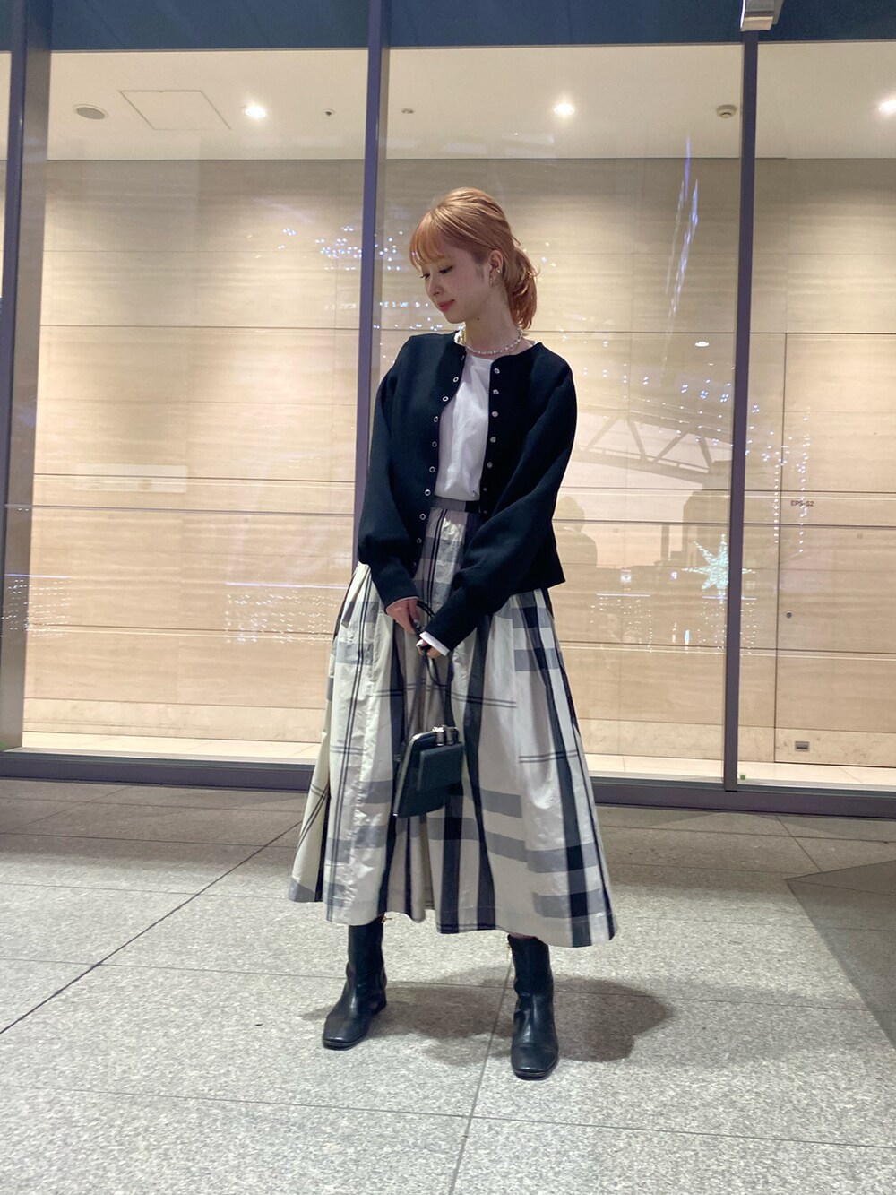 ブラック系のカーディガン/ボレロ、ホワイト系のスカート、ブラック系のショルダーバッグを着用したレディースの冬コーディネートの4枚目の写真