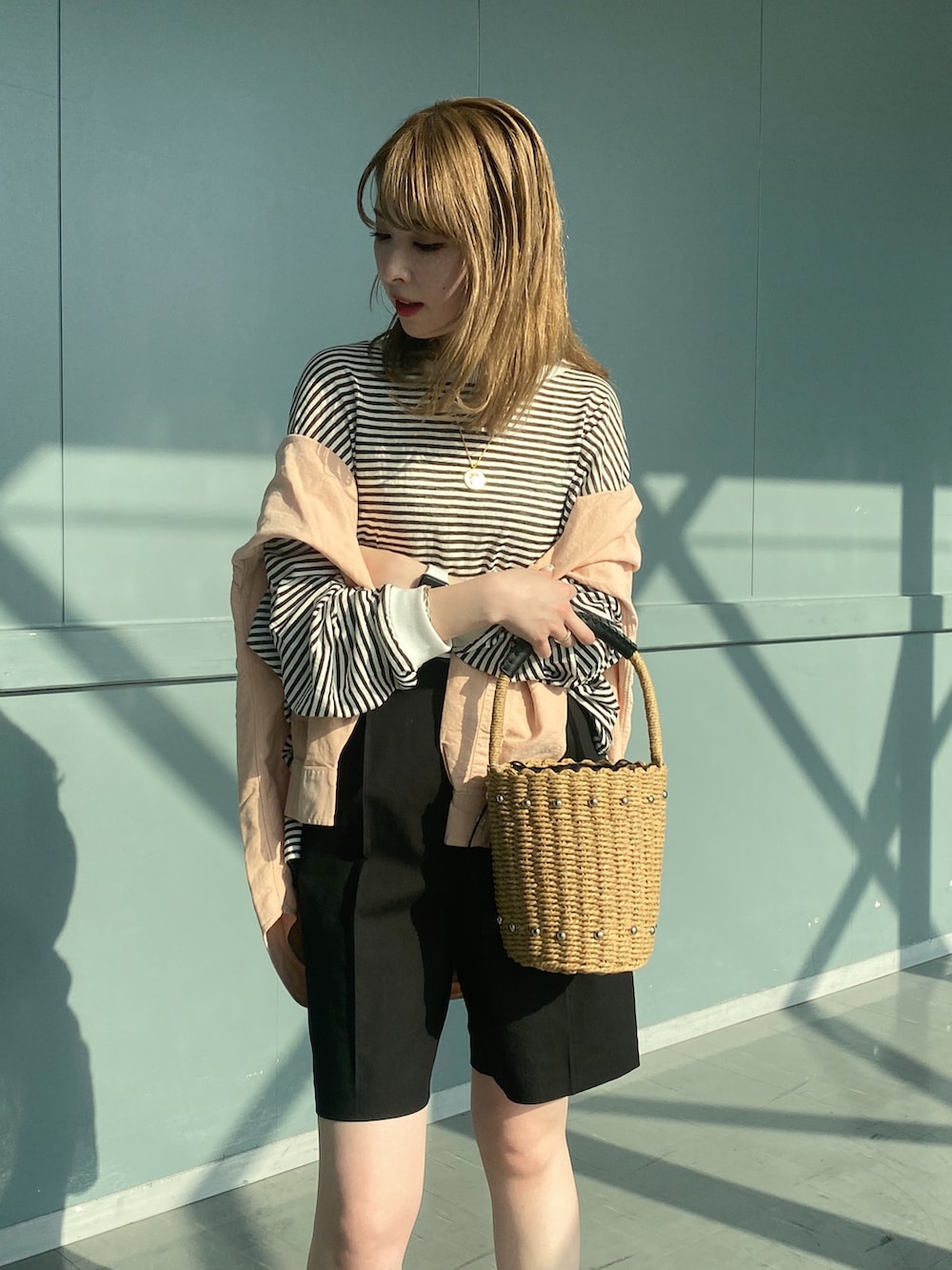 ブラック系のTシャツ/カットソー、ブラック系のその他パンツ、ベージュ系のかごバッグを着用したレディースの春コーディネートの5枚目の写真