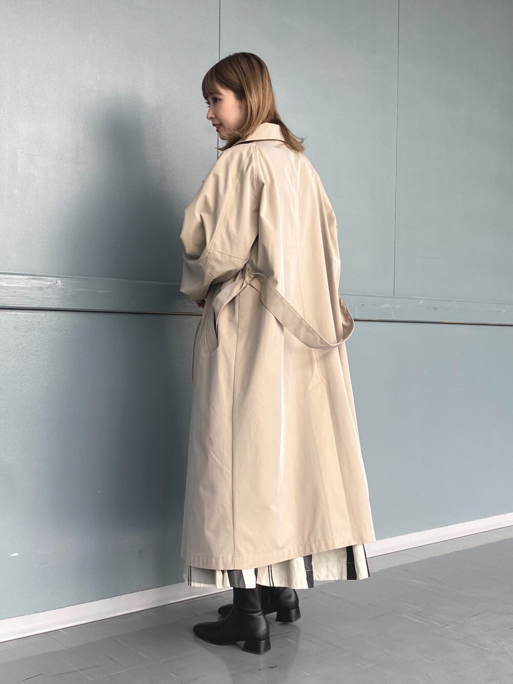 ブルー系のシャツ/ブラウス、ベージュ系のステンカラーコート、ホワイト系のスカートを着用したレディースの冬コーディネートの2枚目の写真