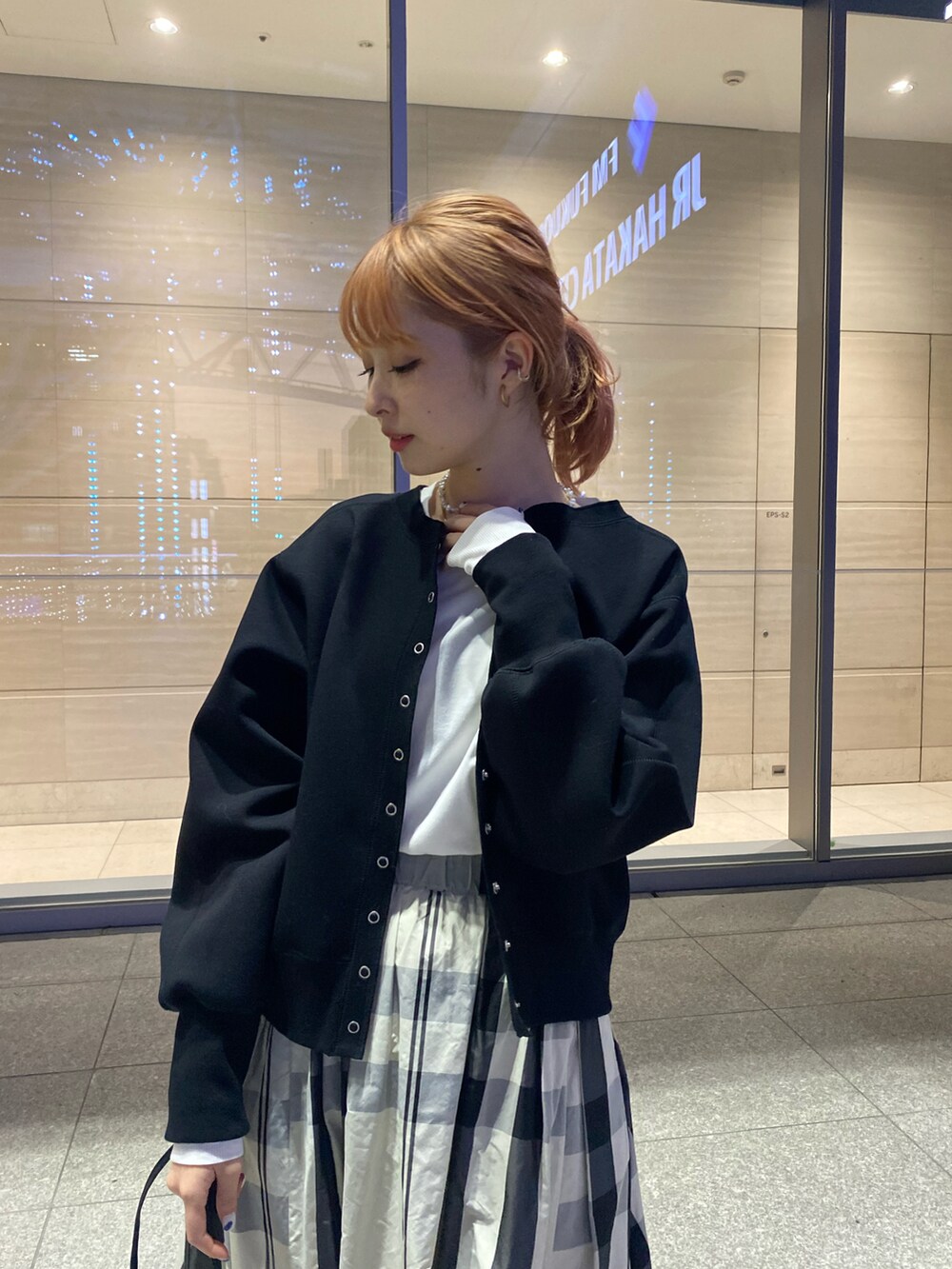 ブラック系のカーディガン/ボレロ、ホワイト系のスカート、ブラック系のショルダーバッグを着用したレディースの冬コーディネートの5枚目の写真