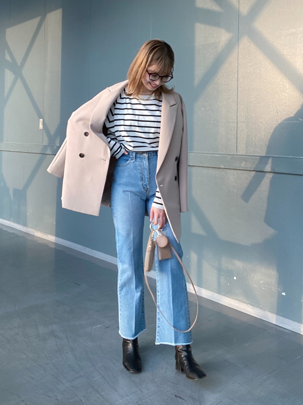 その他のTシャツ/カットソー、ブルー系のデニムパンツ、ベージュ系のショルダーバッグを着用したレディースの冬コーディネートの2枚目の写真