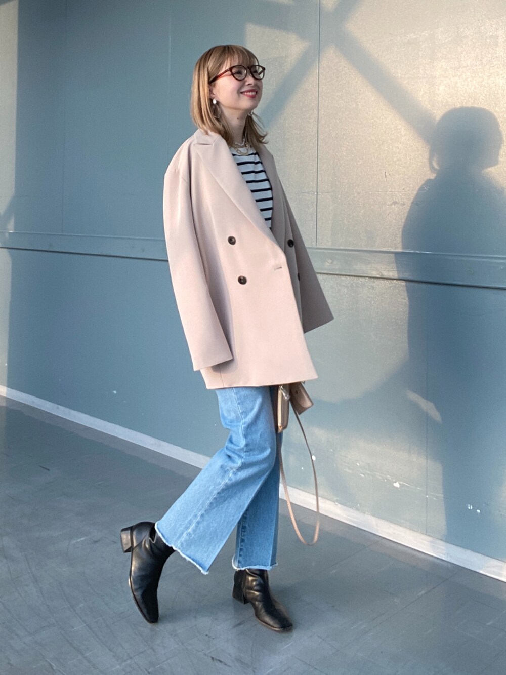 その他のTシャツ/カットソー、ブルー系のデニムパンツ、ベージュ系のショルダーバッグを着用したレディースの冬コーディネートの3枚目の写真