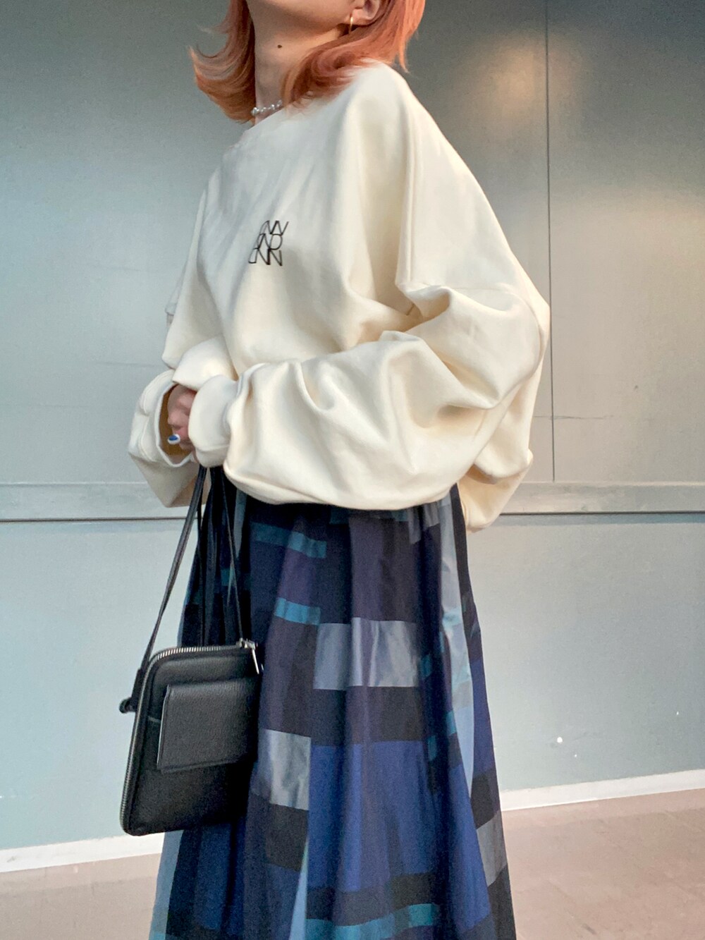 ホワイト系のTシャツ/カットソー、ブルー系のスカート、ブラック系のブーツを着用したレディースの冬コーディネートの4枚目の写真