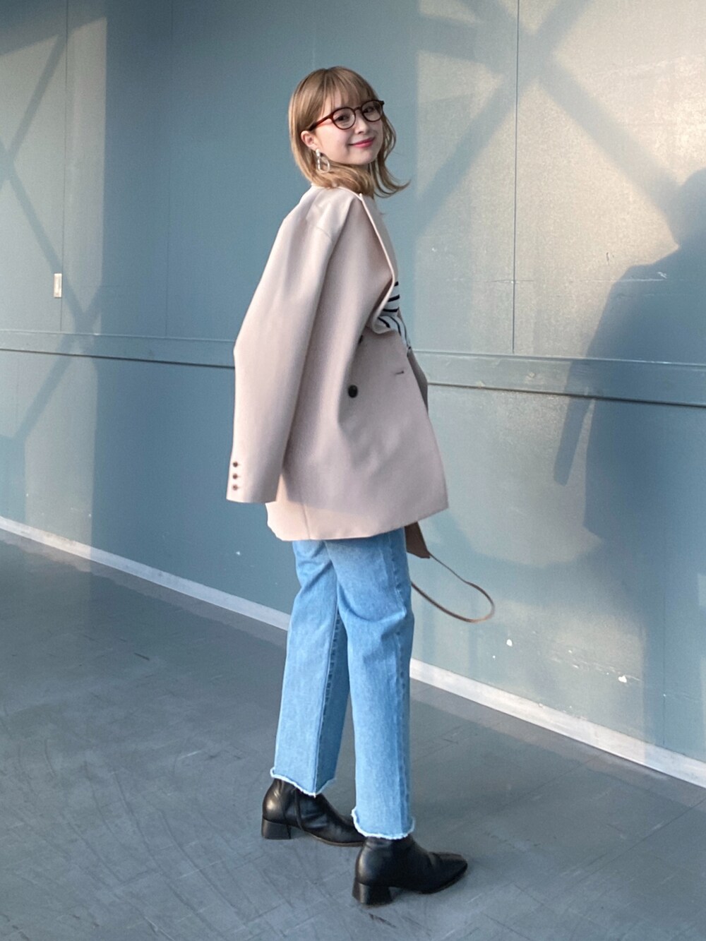 その他のTシャツ/カットソー、ブルー系のデニムパンツ、ベージュ系のショルダーバッグを着用したレディースの冬コーディネートの4枚目の写真