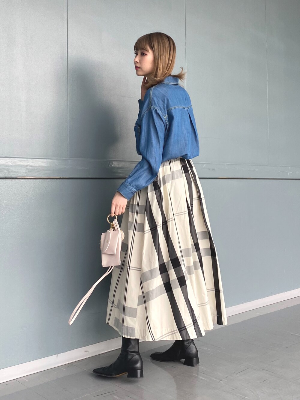 ブルー系のシャツ/ブラウス、ベージュ系のステンカラーコート、ホワイト系のスカートを着用したレディースの冬コーディネートの3枚目の写真