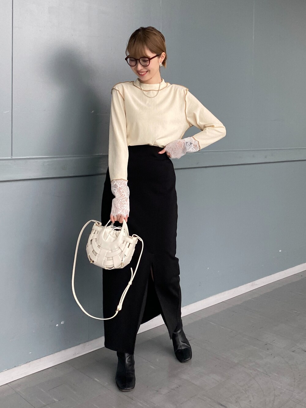 ホワイト系のTシャツ/カットソー、ブラック系のスカート、ホワイト系のショルダーバッグを着用したレディースの冬コーディネートの3枚目の写真