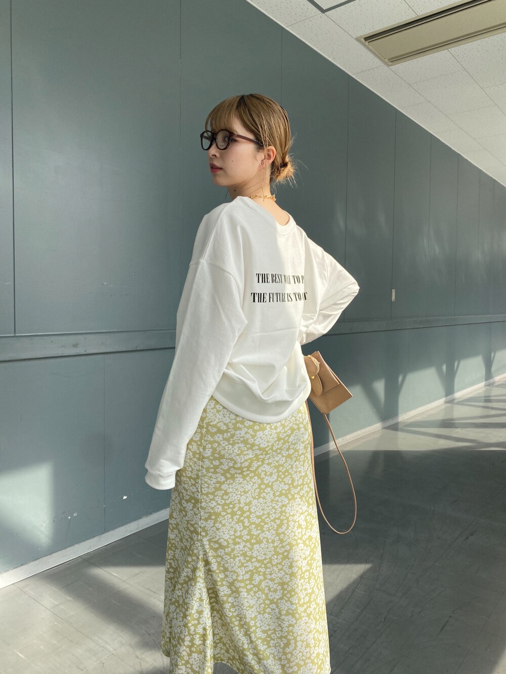 ホワイト系のTシャツ/カットソー、イエロー系のスカート、ベージュ系のショルダーバッグを着用したレディースの冬コーディネートの5枚目の写真