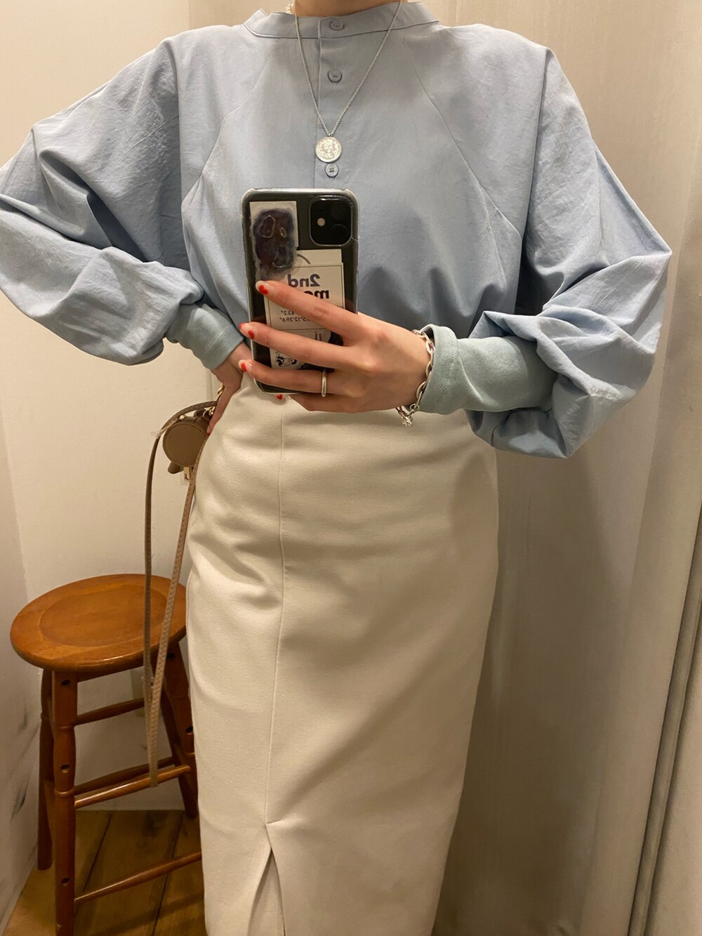 ブルー系のシャツ/ブラウス、ベージュ系のスカート、ベージュ系のショルダーバッグを着用したレディースの冬コーディネートの4枚目の写真