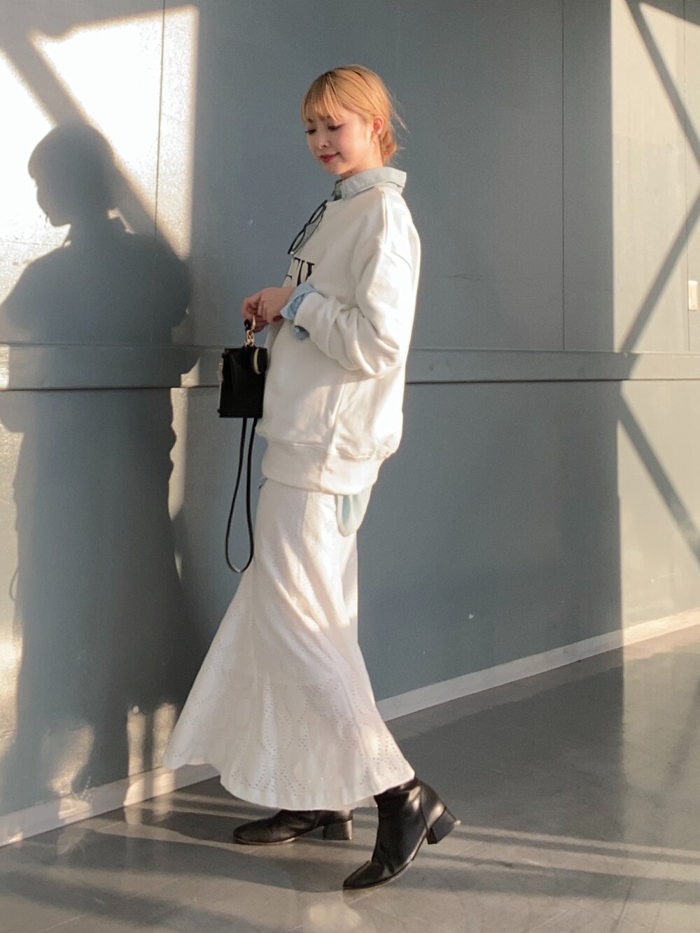 ホワイト系のTシャツ/カットソー、ブルー系のシャツ/ブラウス、ホワイト系のスカートを着用したレディースの冬コーディネートの3枚目の写真