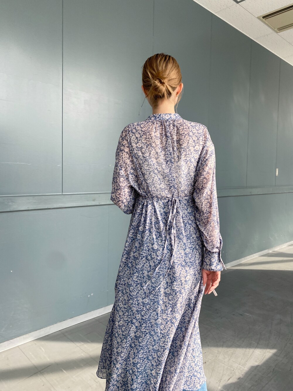 ブルー系のワンピース、ホワイト系のショルダーバッグ、ブルー系のデニムパンツを着用したレディースの冬コーディネートの3枚目の写真