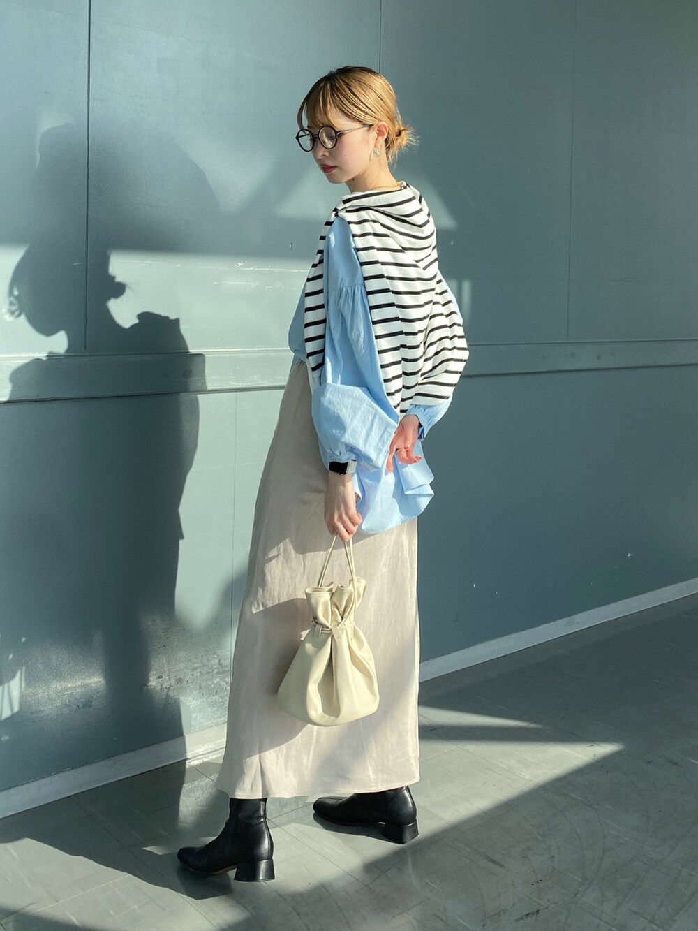 ブルー系のシャツ/ブラウス、ホワイト系のTシャツ/カットソー、ベージュ系のスカートを着用したレディースの春コーディネートの2枚目の写真