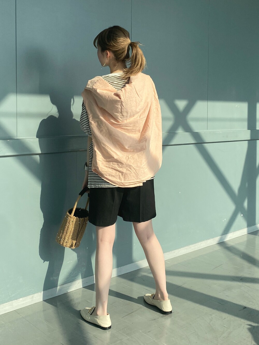 ブラック系のTシャツ/カットソー、ブラック系のその他パンツ、ベージュ系のかごバッグを着用したレディースの春コーディネートの3枚目の写真