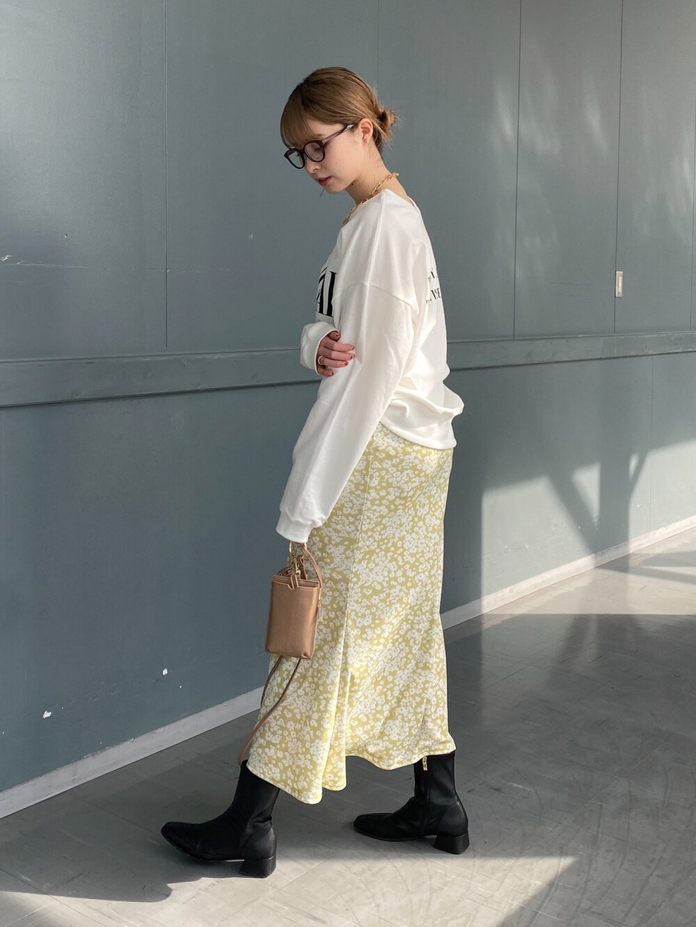 ホワイト系のTシャツ/カットソー、イエロー系のスカート、ベージュ系のショルダーバッグを着用したレディースの冬コーディネートの3枚目の写真