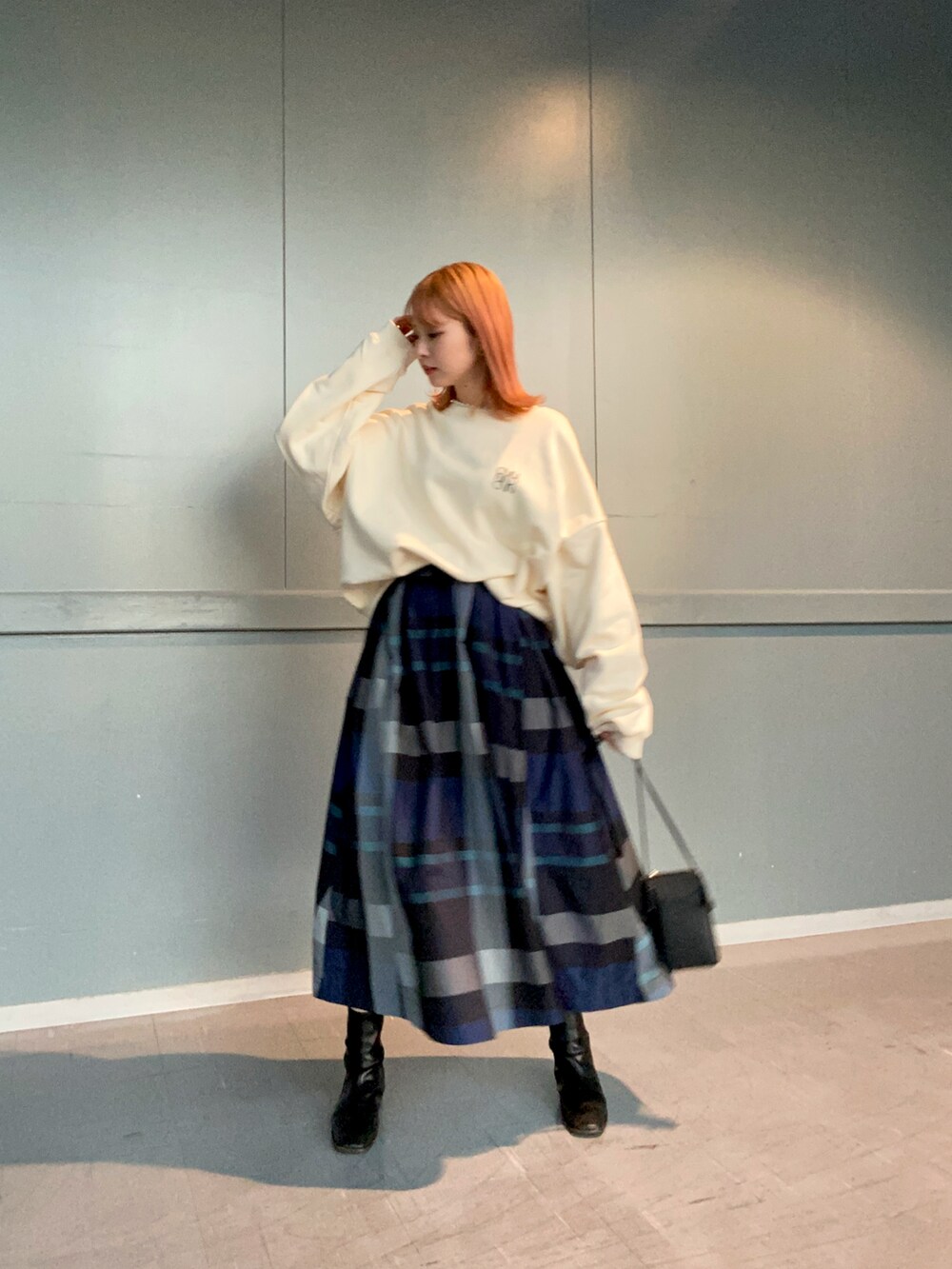 ホワイト系のTシャツ/カットソー、ブルー系のスカート、ブラック系のブーツを着用したレディースの冬コーディネートの3枚目の写真