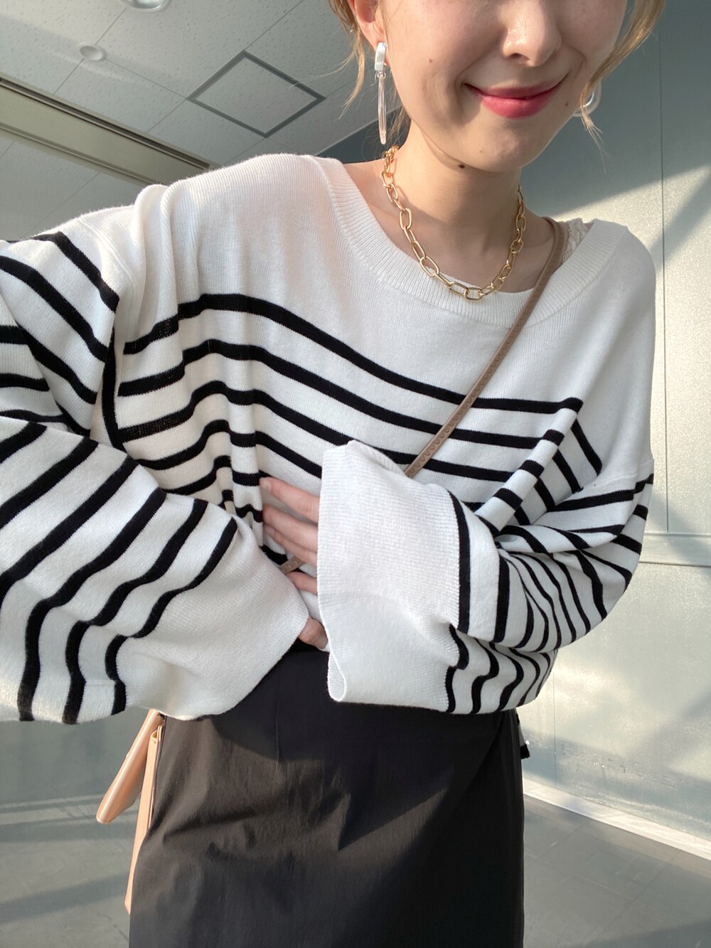 ブラック系のニット/セーター、ブラック系のスカート、ベージュ系のショルダーバッグを着用したレディースの冬コーディネートの5枚目の写真