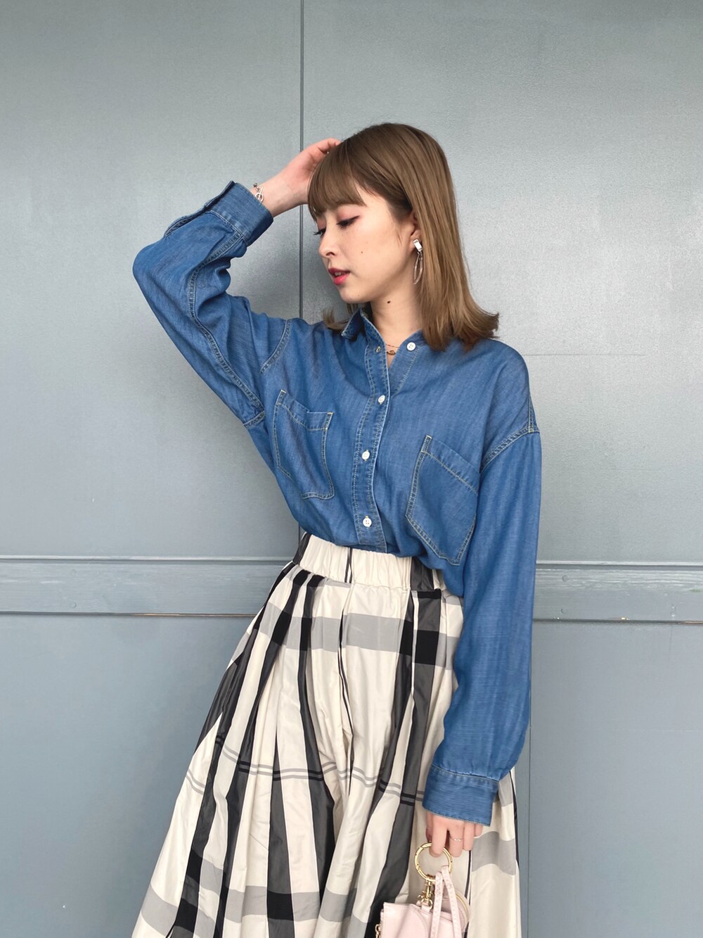 ブルー系のシャツ/ブラウス、ベージュ系のステンカラーコート、ホワイト系のスカートを着用したレディースの冬コーディネートの4枚目の写真