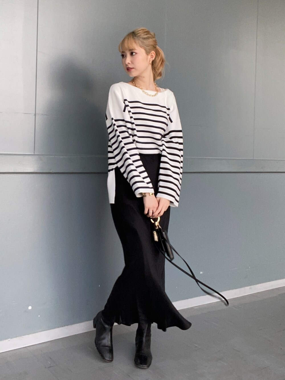 ブラック系のニット/セーター、ブルー系のテーラードジャケット、ブラック系のスカートを着用したレディースの冬コーディネートの3枚目の写真