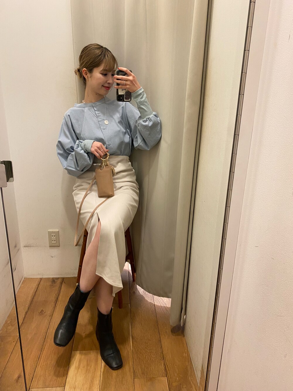 ブルー系のシャツ/ブラウス、ベージュ系のスカート、ベージュ系のショルダーバッグを着用したレディースの冬コーディネートの2枚目の写真