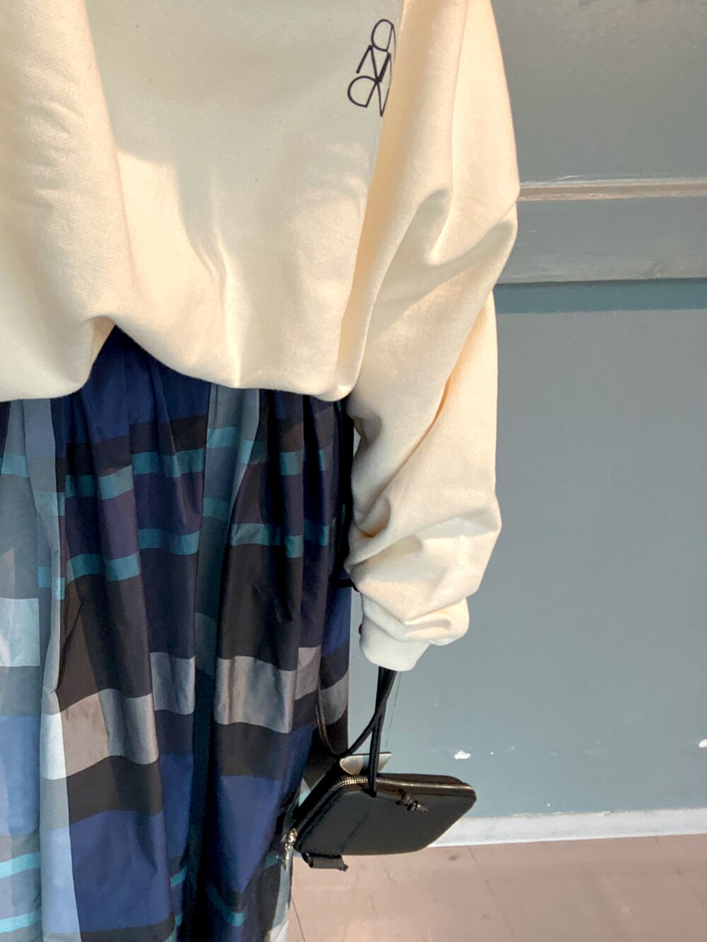 ホワイト系のTシャツ/カットソー、ブルー系のスカート、ブラック系のブーツを着用したレディースの冬コーディネートの5枚目の写真