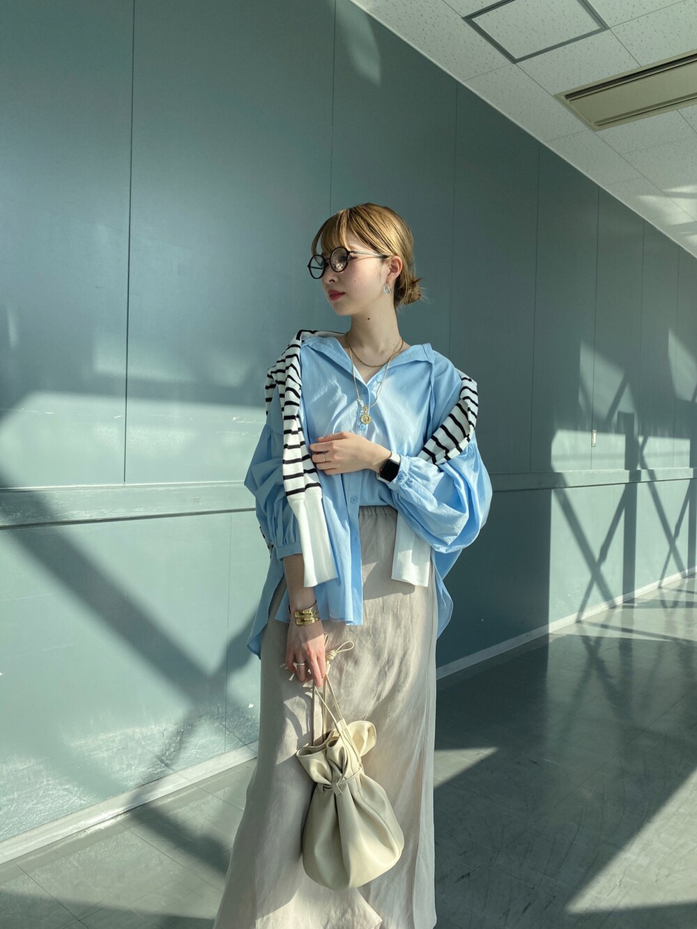 ブルー系のシャツ/ブラウス、ホワイト系のTシャツ/カットソー、ベージュ系のスカートを着用したレディースの春コーディネートの3枚目の写真