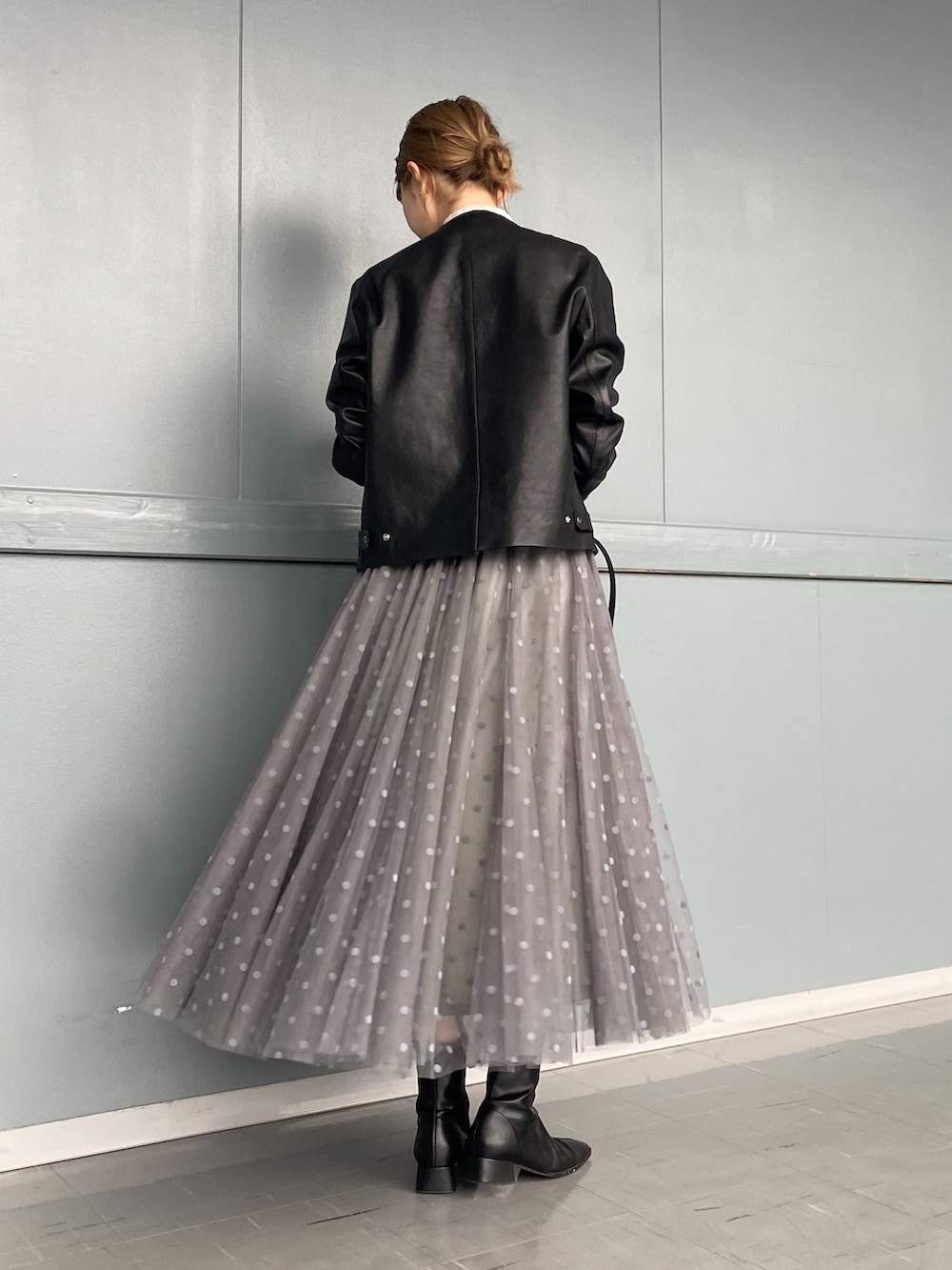 ホワイト系のTシャツ/カットソー、ブラック系のノーカラージャケット、グレー系のスカートを着用したレディースの冬コーディネートの3枚目の写真