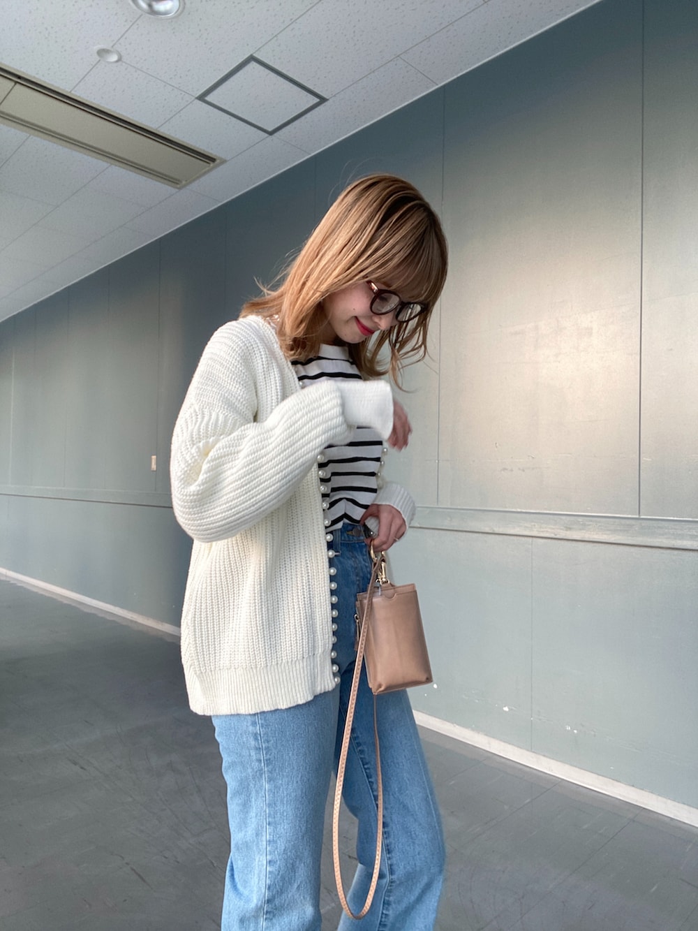 ブルー系のデニムパンツ、その他のTシャツ/カットソー、ホワイト系のカーディガン/ボレロを着用したレディースの冬コーディネートの2枚目の写真