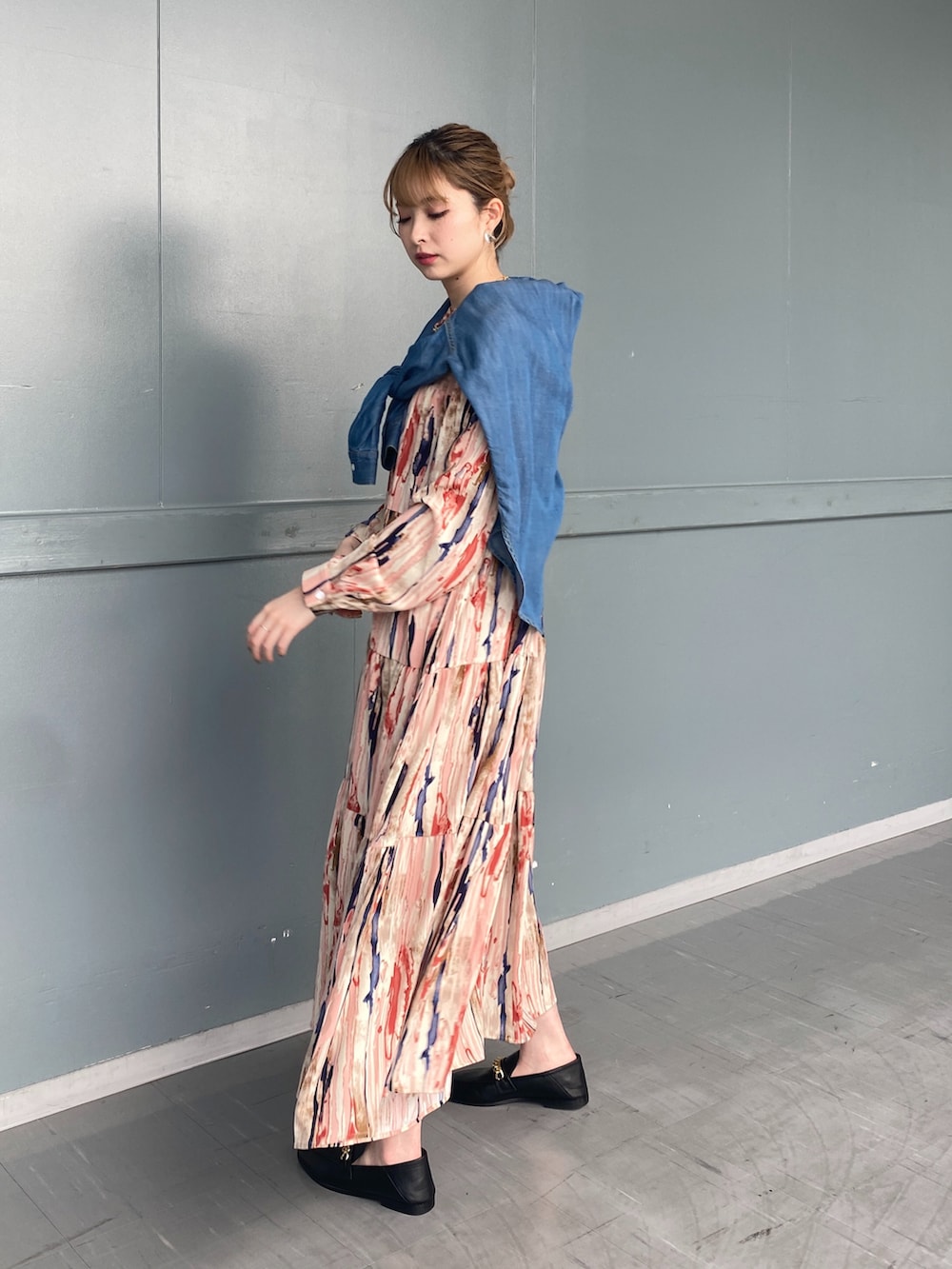 レッド系のワンピース、ブルー系のシャツ/ブラウス、ブラック系のローファーを着用したレディースの春コーディネートの2枚目の写真