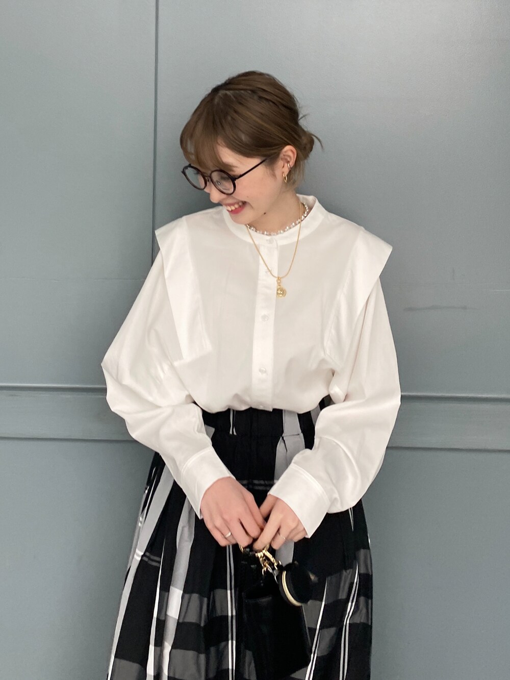 ホワイト系のシャツ/ブラウス、ブラック系のスカートを着用したレディースの冬コーディネートの3枚目の写真