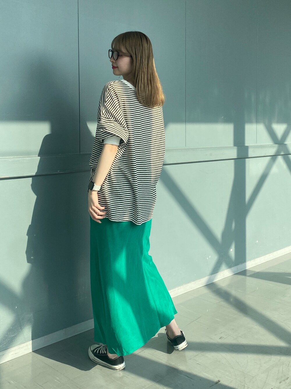 ブラック系のTシャツ/カットソー、グリーン系のスカート、ホワイト系のショルダーバッグを着用したレディースの春コーディネートの4枚目の写真