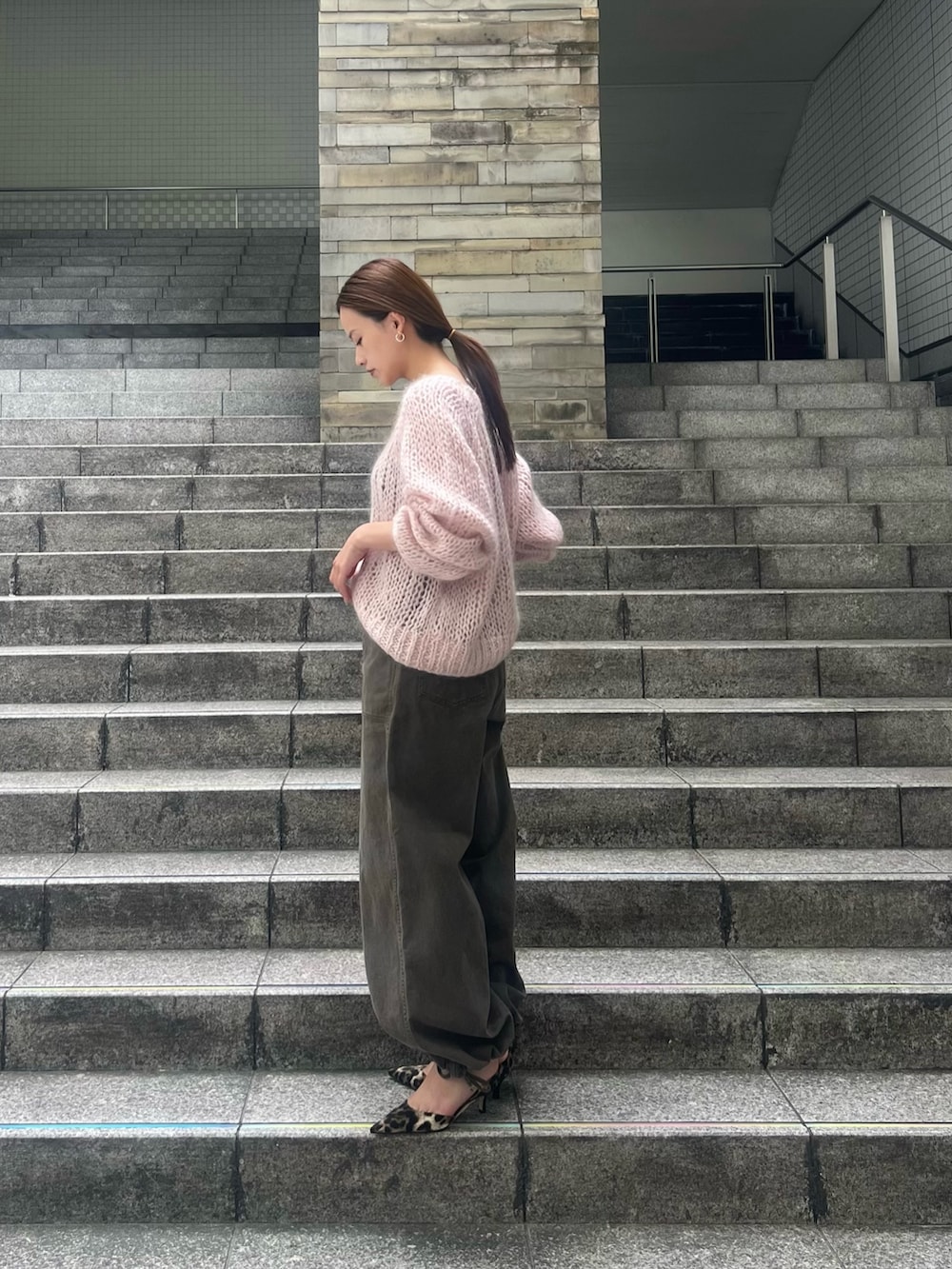 ピンク系のニット/セーター、ブラウン系のその他パンツ、イエロー系のパンプスを着用したレディースの秋コーディネートの2枚目の写真