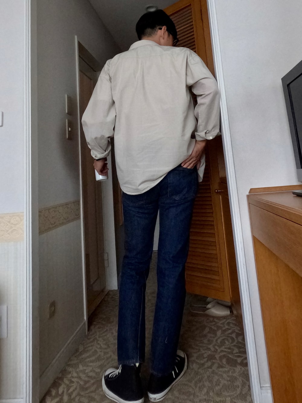 ブルー系のデニムパンツ、ブラック系のスニーカー、ベージュ系のシャツ/ブラウスを着用したメンズの春コーディネートの2枚目の写真