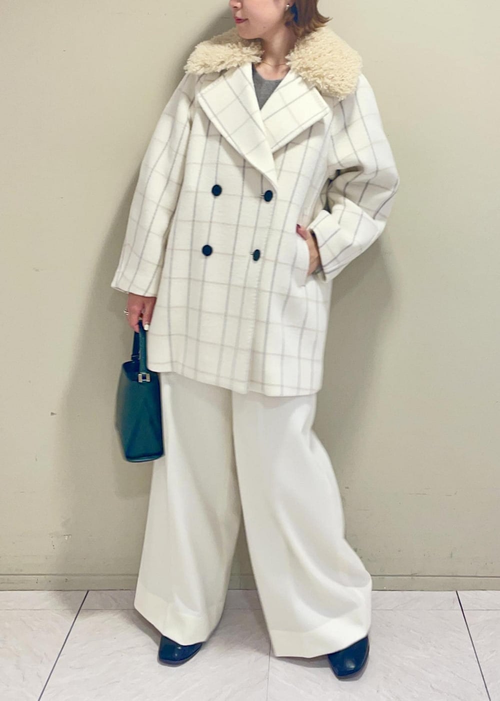ホワイト系のチェスターコート、グリーン系のショルダーバッグ、ブラウン系のニット/セーターを着用したレディースの秋コーディネートの4枚目の写真