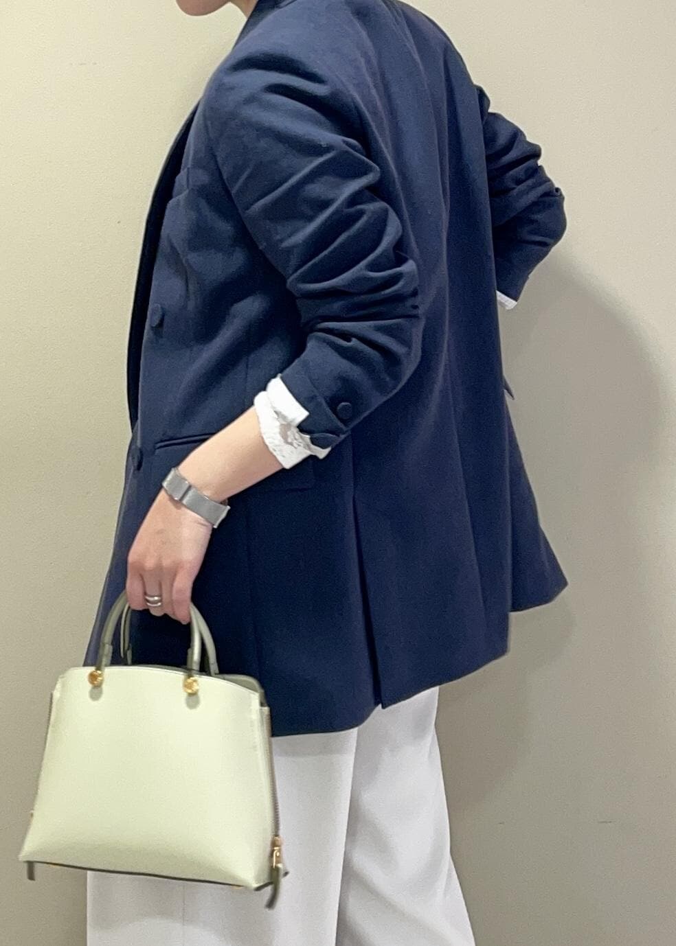 ホワイト系のその他パンツ、グリーン系のハンドバッグ、ブラック系のパンプスを着用したレディースの春コーディネートの6枚目の写真