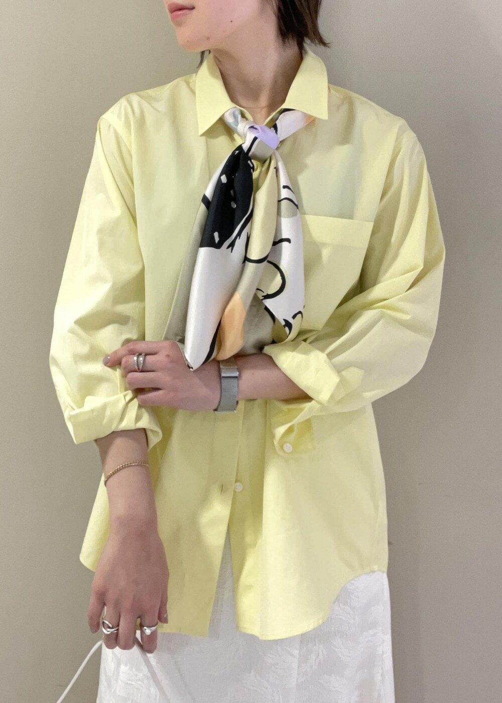 ベージュ系のハンドバッグ、イエロー系のシャツ/ブラウス、ベージュ系のパンプスを着用したレディースの春コーディネートの7枚目の写真