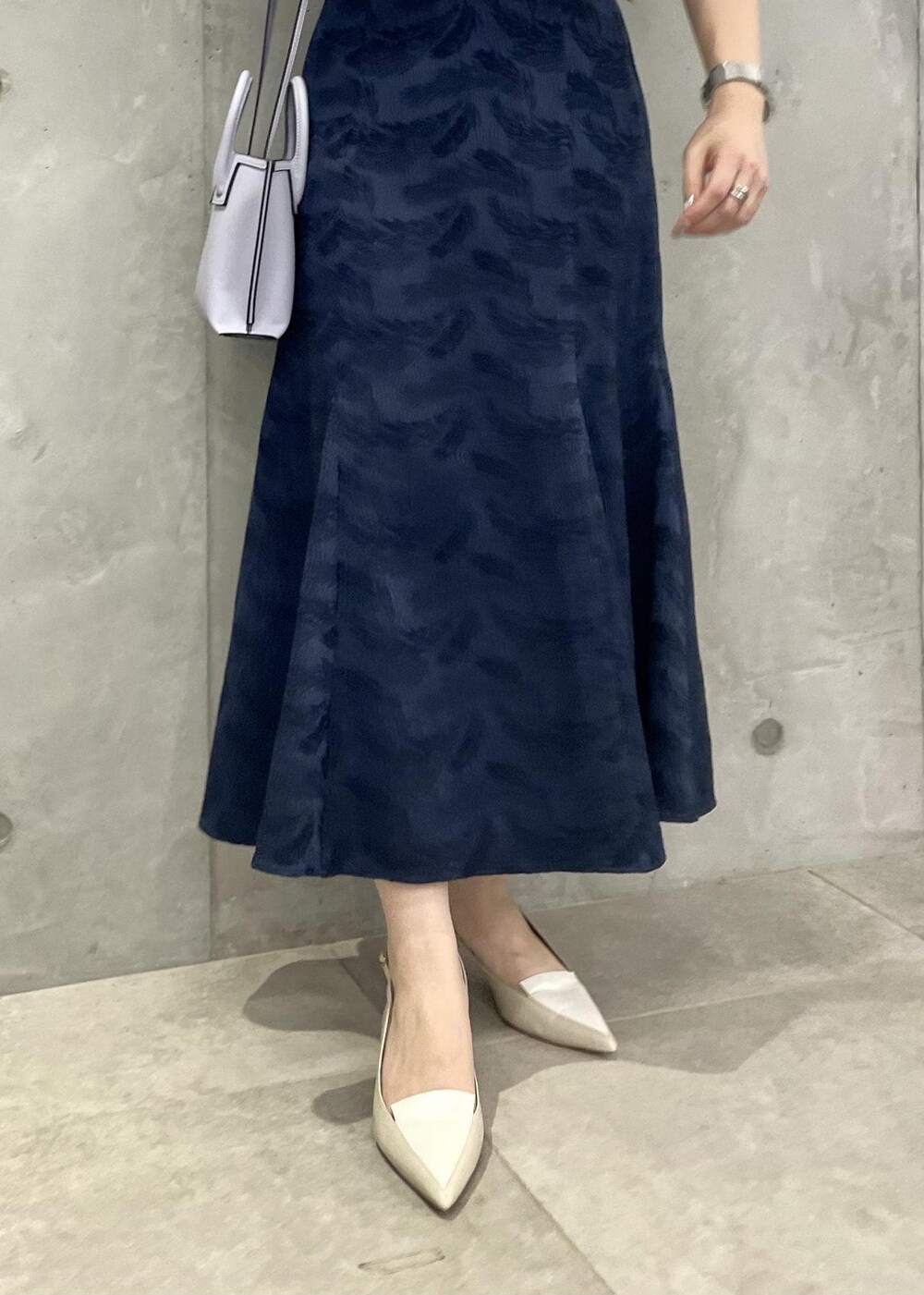 ベージュ系のパンプス、ブルー系のスカート、ホワイト系のTシャツ/カットソーを着用したレディースの春コーディネートの7枚目の写真