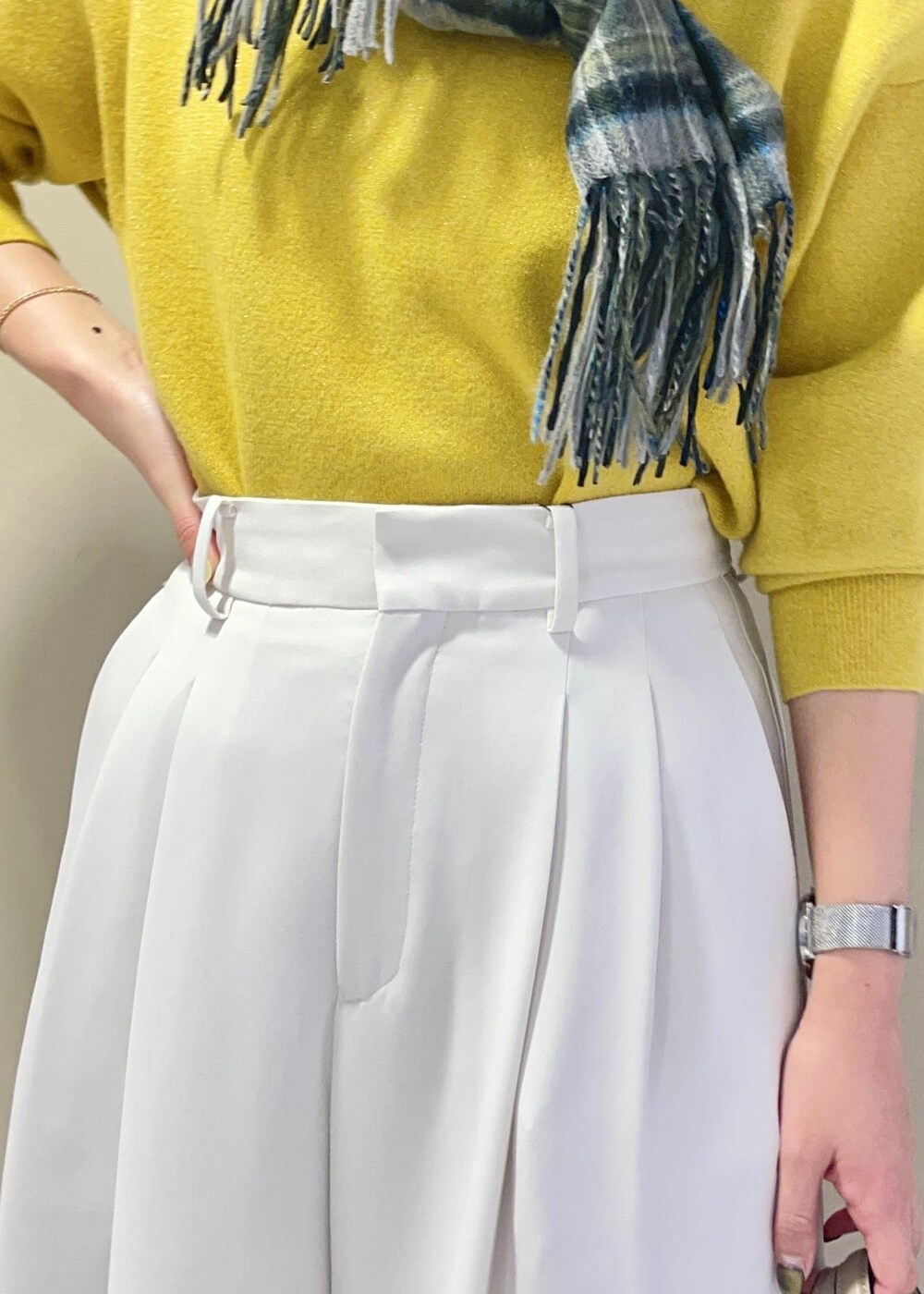 ベージュ系のハンドバッグ、ブラック系のブーツ、イエロー系のニット/セーターを着用したレディースの冬コーディネートの8枚目の写真