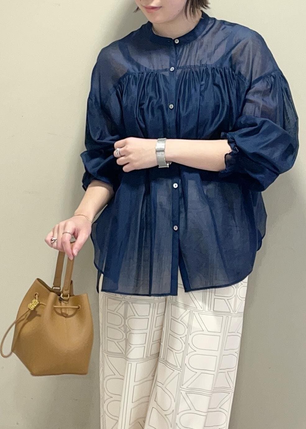 イエロー系のハンドバッグ、ホワイト系のその他パンツ、ブルー系のシャツ/ブラウスを着用したレディースの冬コーディネートの7枚目の写真