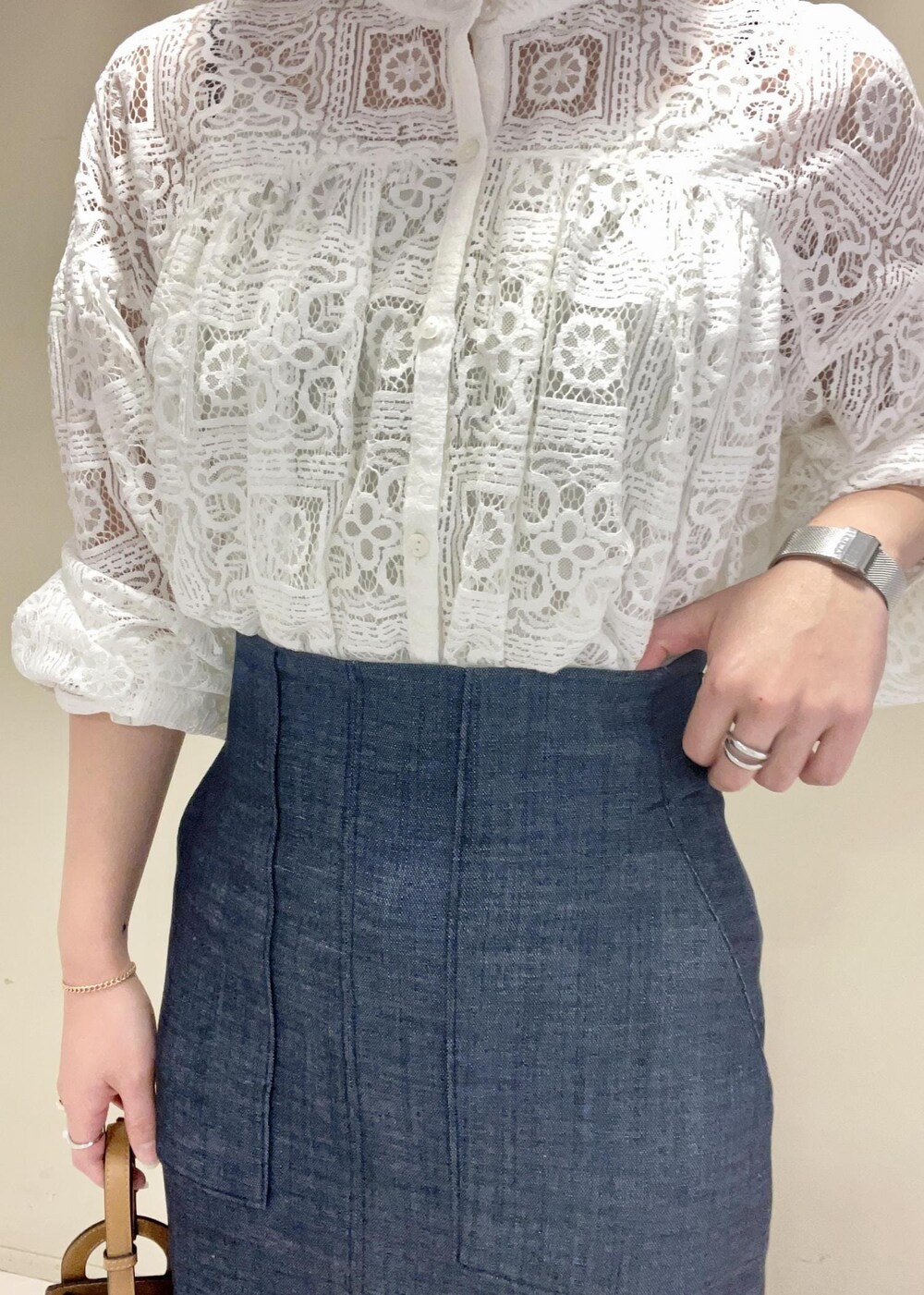 イエロー系のショルダーバッグ、ブルー系のスカート、ブラック系のパンプスを着用したレディースの冬コーディネートの9枚目の写真