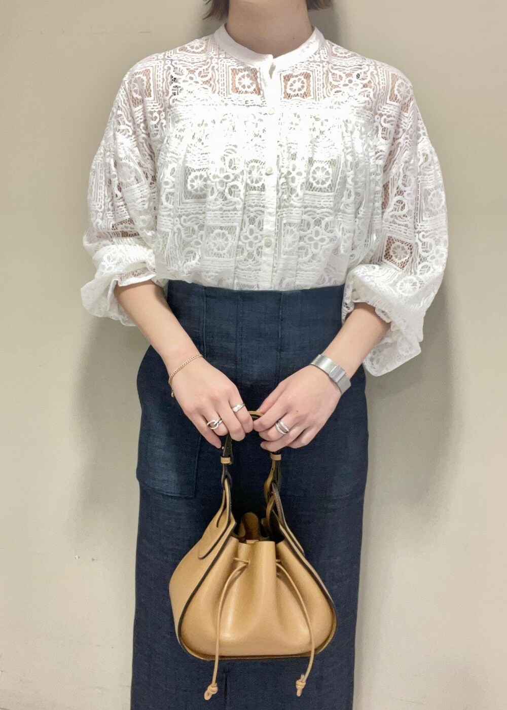 イエロー系のショルダーバッグ、ブルー系のスカート、ブラック系のパンプスを着用したレディースの冬コーディネートの8枚目の写真