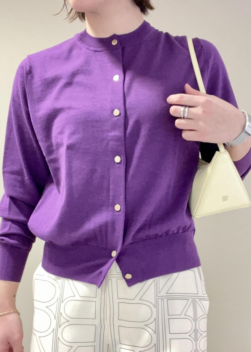 ベージュ系のハンドバッグ、ホワイト系のその他パンツ、パープル系のカーディガン/ボレロを着用したレディースの冬コーディネートの7枚目の写真