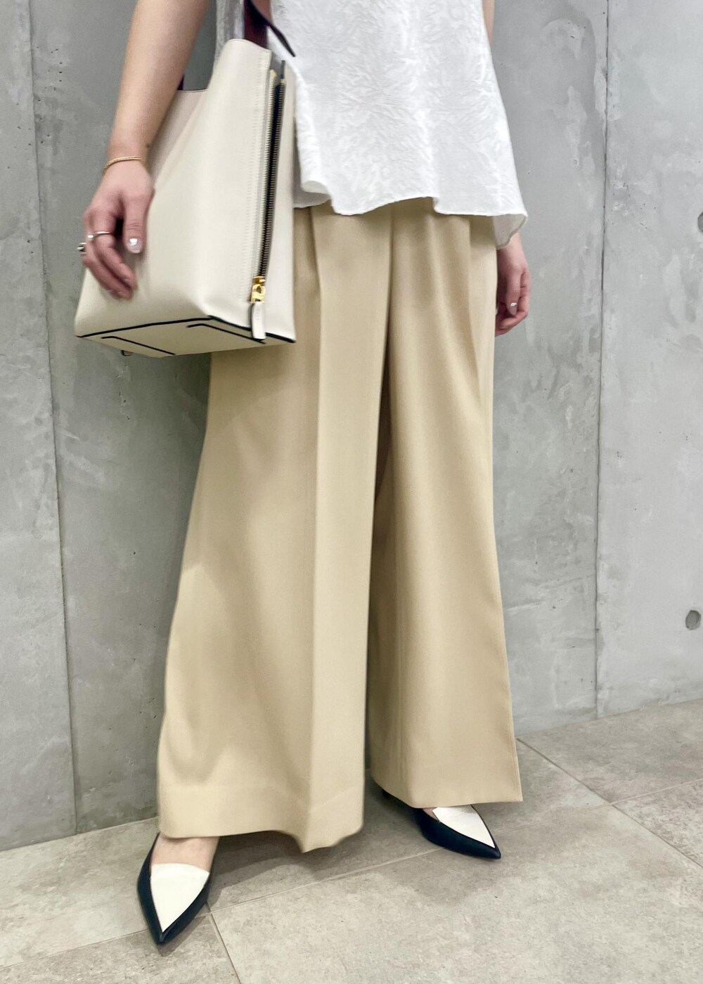 ホワイト系のショルダーバッグ、ブラック系のパンプス、ホワイト系のシャツ/ブラウスを着用したレディースの春コーディネートの8枚目の写真