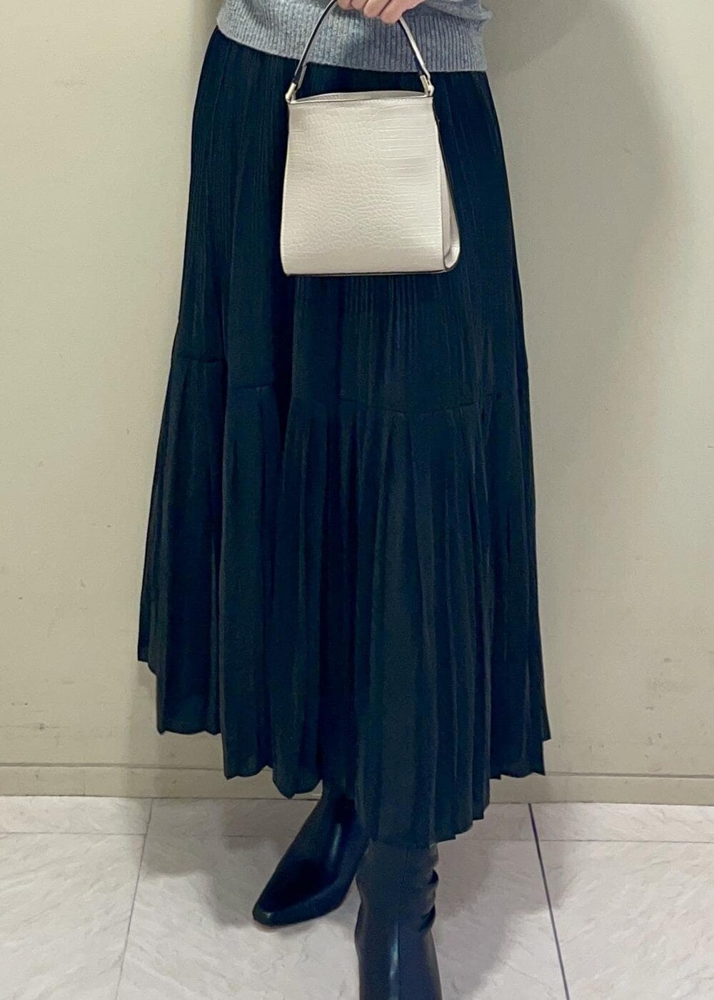 ブラック系のブーツ、ブラック系のスカート、ベージュ系のショルダーバッグを着用したレディースの秋コーディネートの5枚目の写真