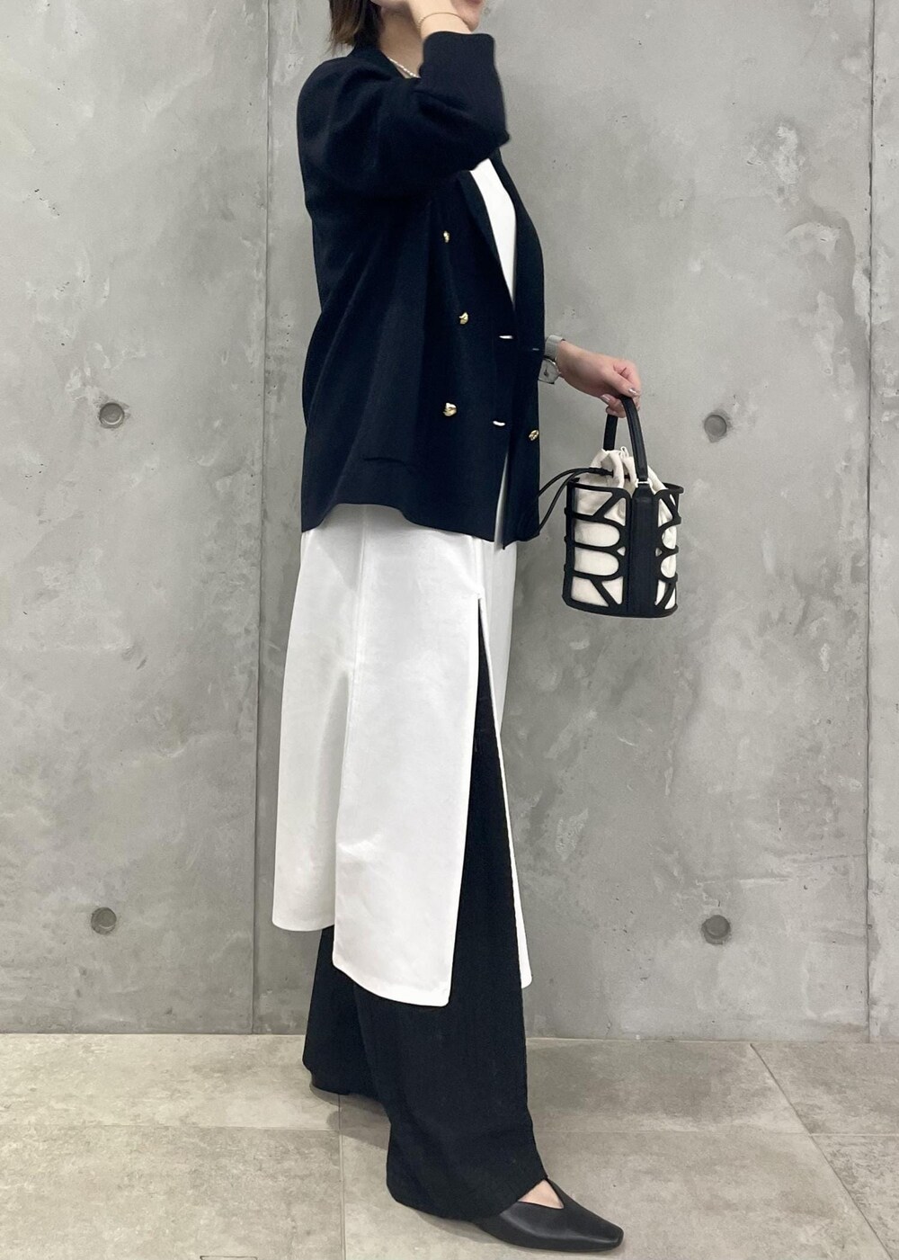 ブラック系のハンドバッグ、ブルー系のテーラードジャケット、ブラック系のその他パンツを着用したレディースの春コーディネートの3枚目の写真