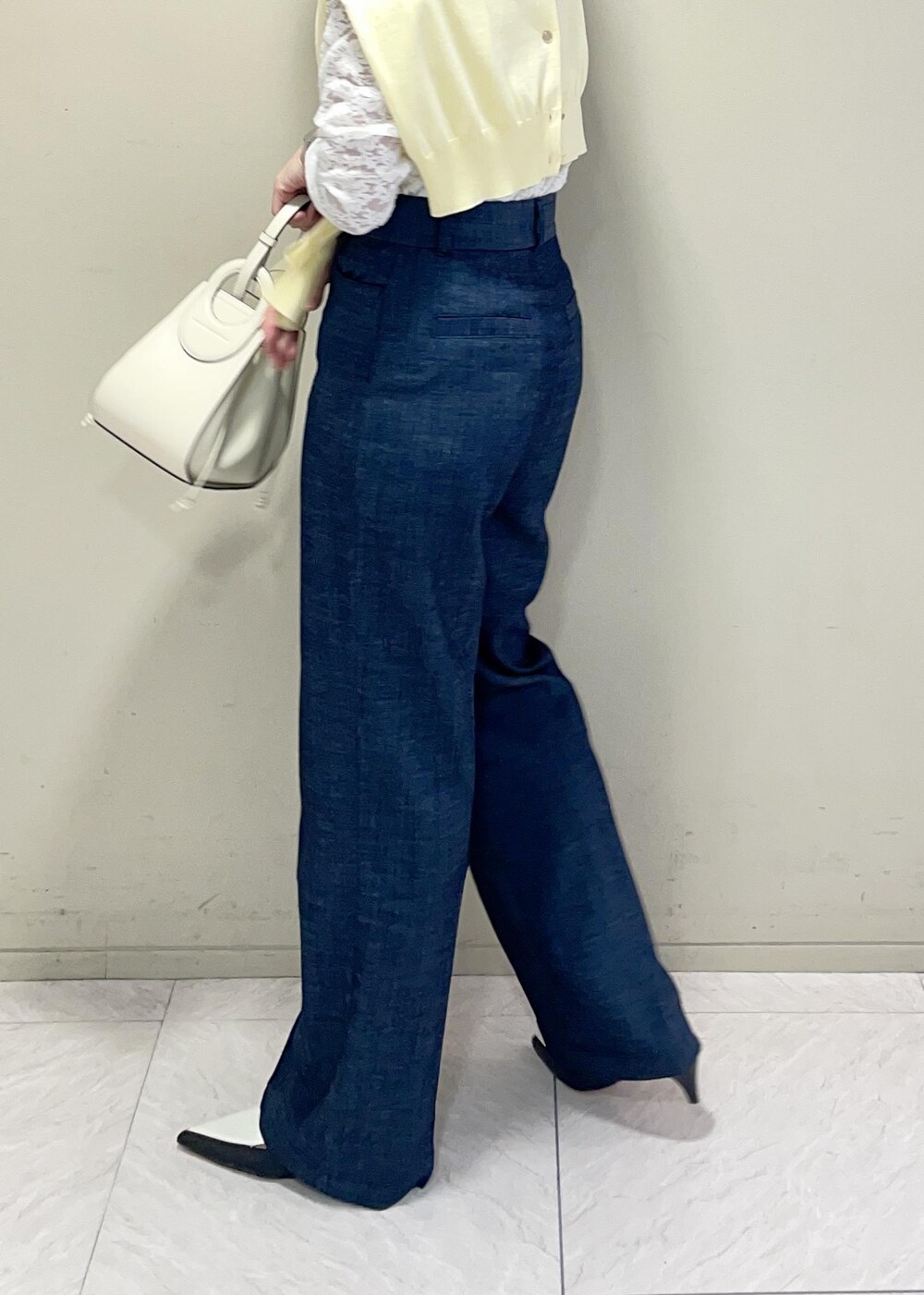 ブラック系のパンプス、イエロー系のカーディガン/ボレロ、ホワイト系のTシャツ/カットソーを着用したレディースの春コーディネートの7枚目の写真