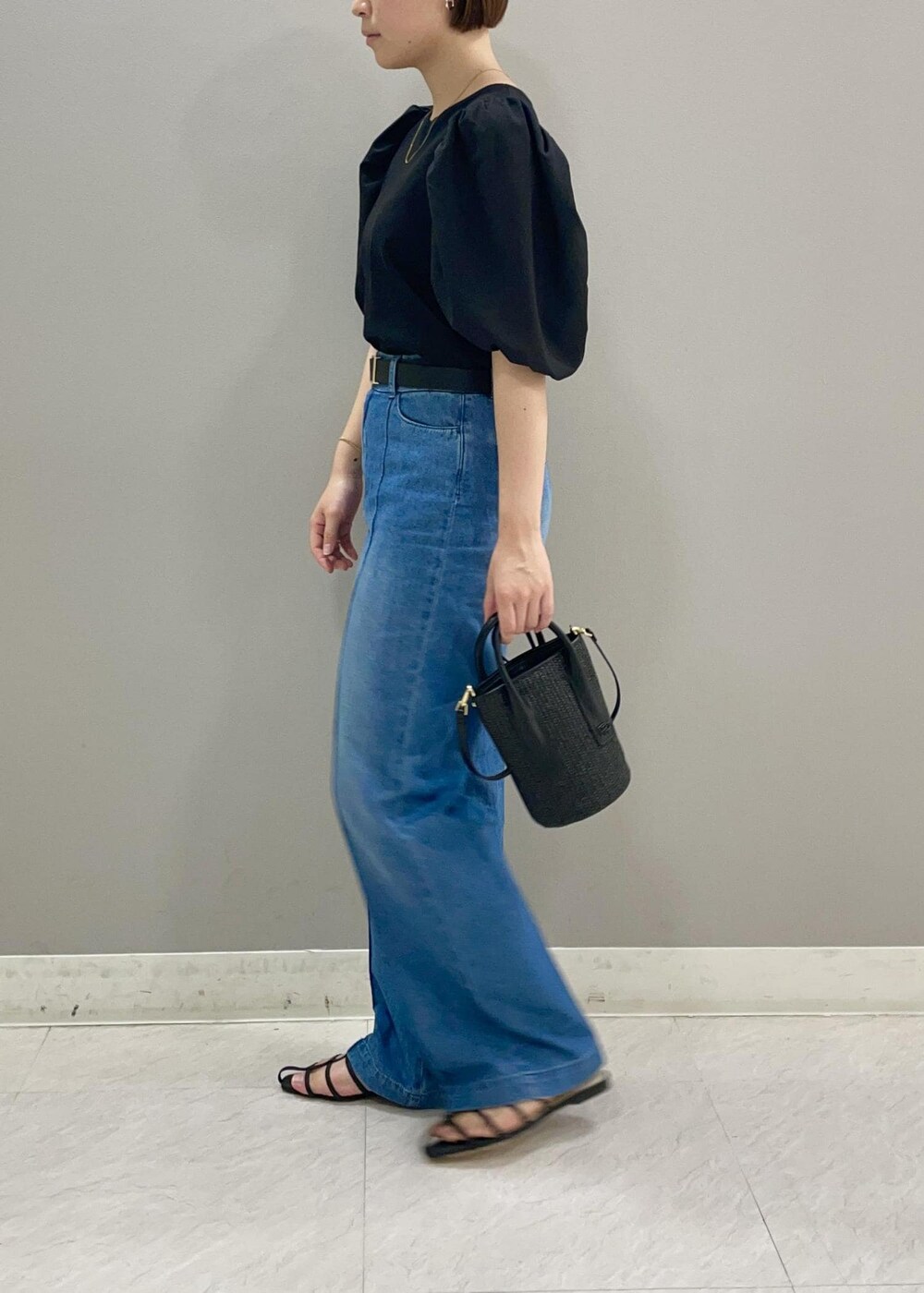 ブラック系のサンダル、ブラック系のハンドバッグ、ブラック系のTシャツ/カットソーを着用したレディースの夏コーディネートの3枚目の写真